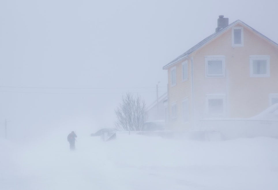 Gult hus i snøstorm. Foto. 